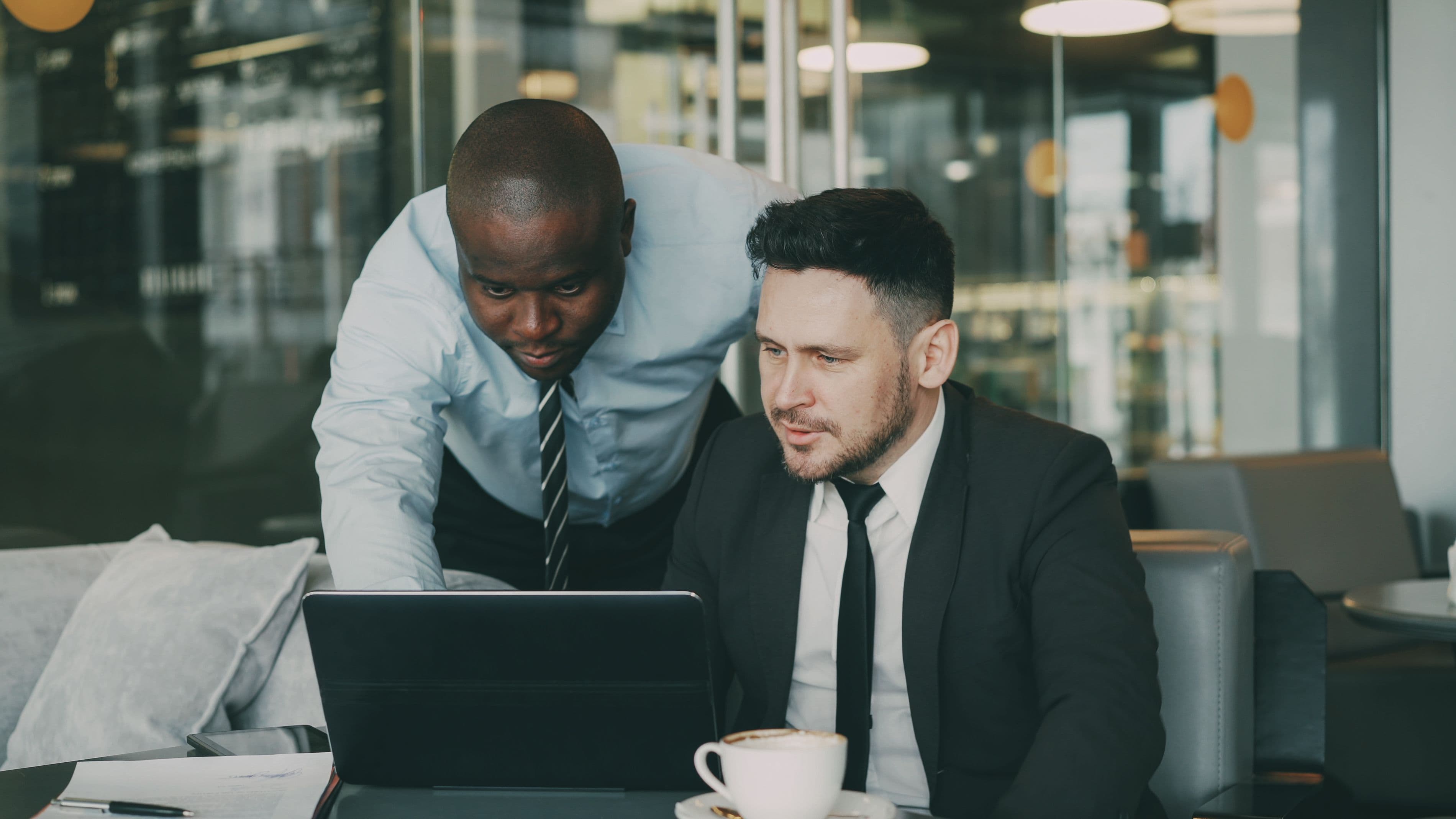 Two business professionals collaborating on an AI strategy over a laptop